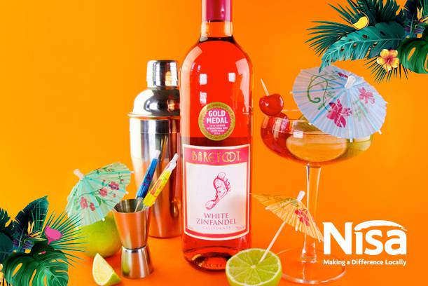 A bottle of pink wine, a cocktail glass with a paper umbrella, and cocktail tools against a bright orange background with tropical leaves and fruit slices.