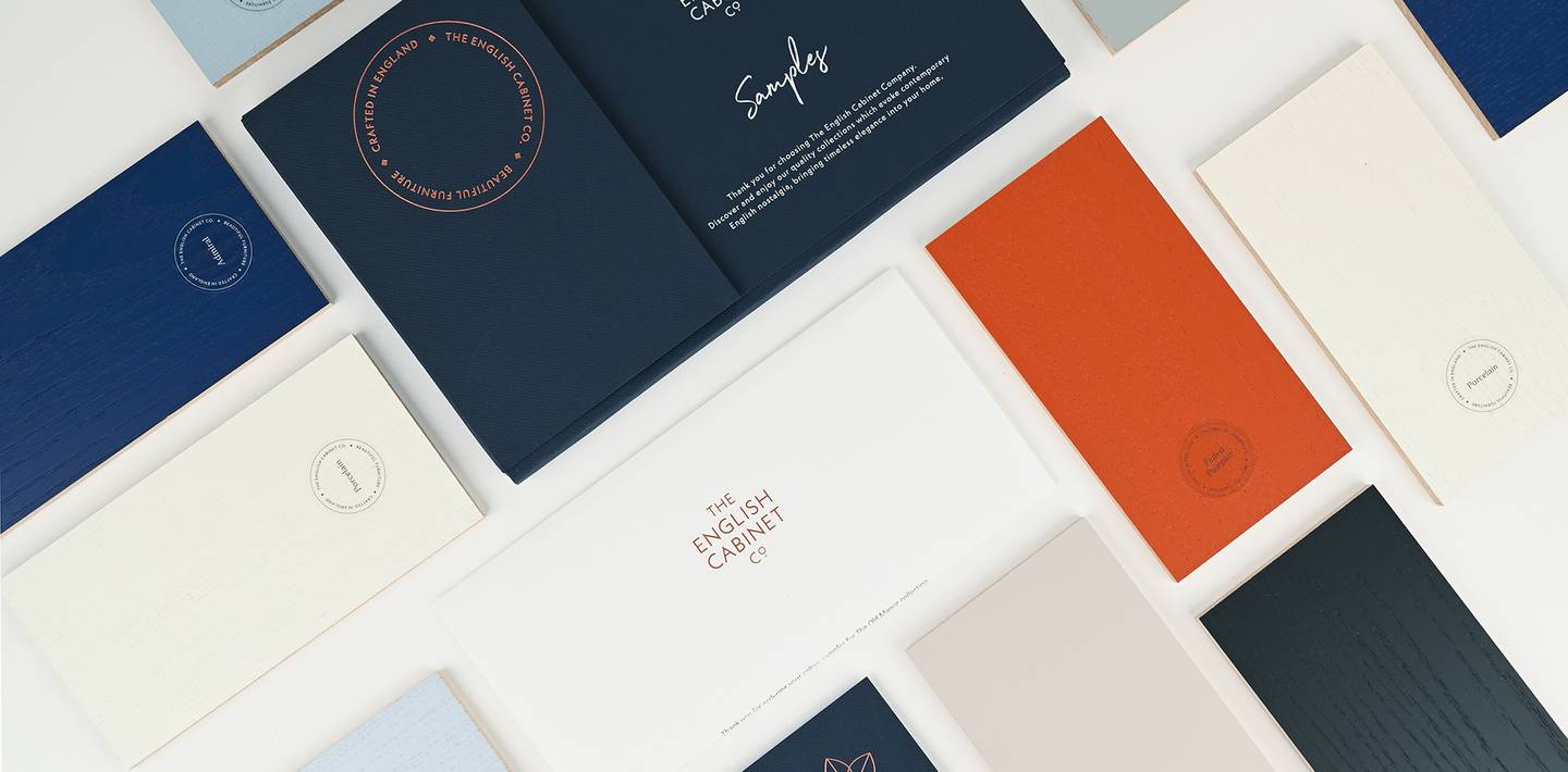 Various coloured booklets and packaging for The English Cabinet Co. are arranged on a white background.