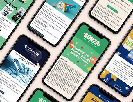 A flat lay of multiple smartphones showcasing colorful marketing emails, featuring bright designs and engaging text about various promotions.