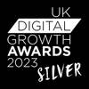 Silver award badge for the UK Digital Growth Awards 2023, featuring a stylised ribbon and text in white against a transparent background.