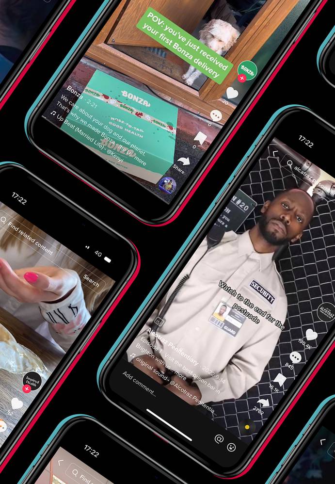 Multiple smartphone screens displaying various TikTok videos, including a security guard, a person with pink nails, a puppy, and a drink on a wooden table.