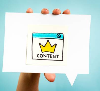 Hand holding a paper with a colourful illustration of a web browser window showing a yellow crown and the word "CONTENT".