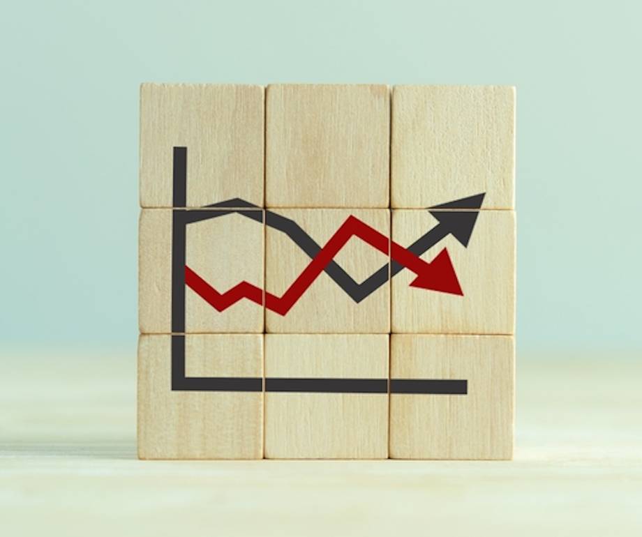 A wooden block puzzle with a black and red line graph showing fluctuations, set against a light background.