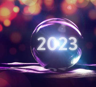 A glass sphere with "2023" illuminated inside, positioned on a purple ribbon, surrounded by colourful bokeh lights, symbolising the new year.