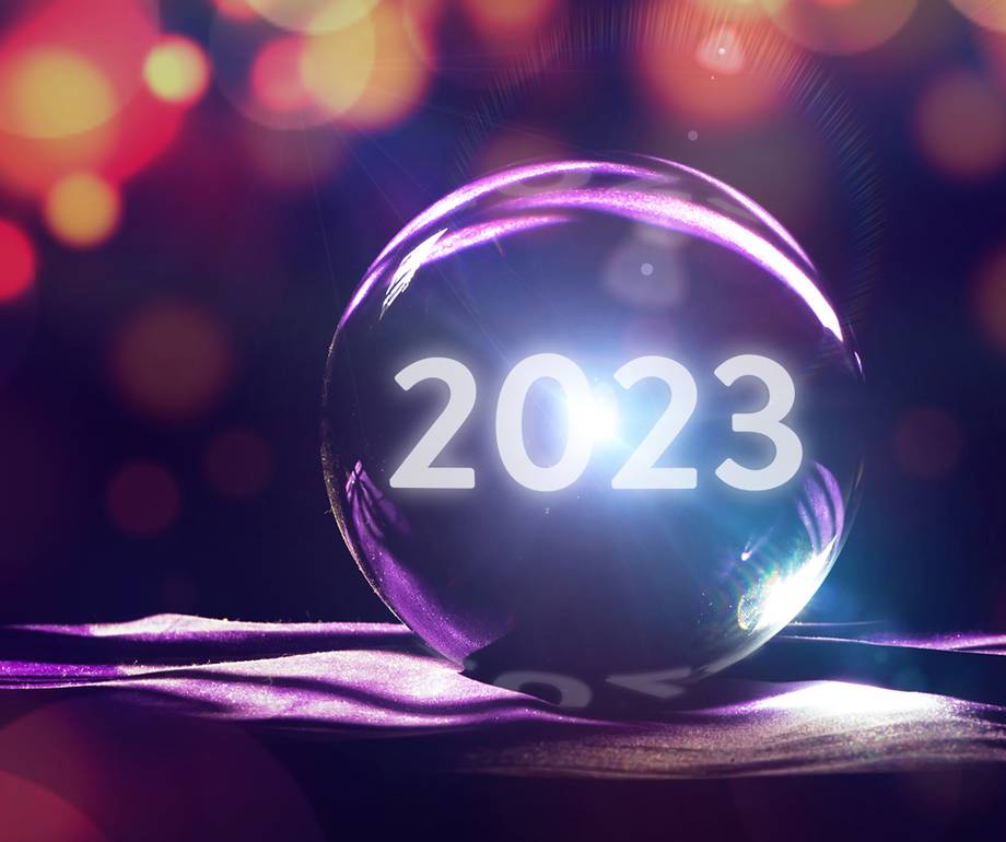 A glass sphere with "2023" illuminated inside, positioned on a purple ribbon, surrounded by colourful bokeh lights, symbolising the new year.