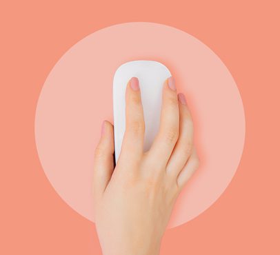 A hand using a white computer mouse on a pink background with a darker pink circle surrounding the mouse.