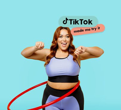 A woman with red hair wearing workout clothes, smiling and flexing her arms, with the TikTok logo and "made me try it" text above her.