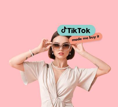 Woman with short brown hair wearing sunglasses, pearl jewelry, a beige dress, with TikTok logos and text overlay that says "made me buy it" against a pink background.