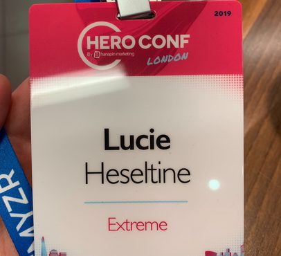 Conference badge with the name Lucie Heseltine, "Extreme" written below, and "HERO CONF London" branding at the top.