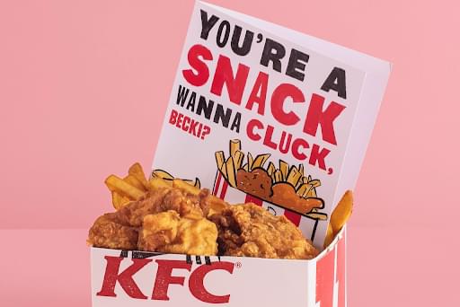 A card which says, "You're a snack becky, wanna cluck?" place in a box of fried chicken