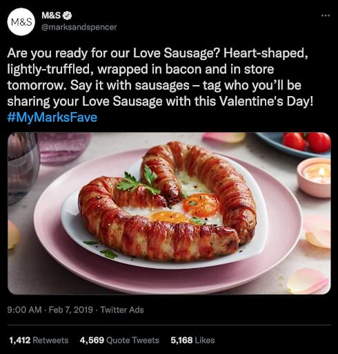 A screenshot of a tweet from Marks and Spencer showing the Love Sausage, filled with two fried eggs in the centre.