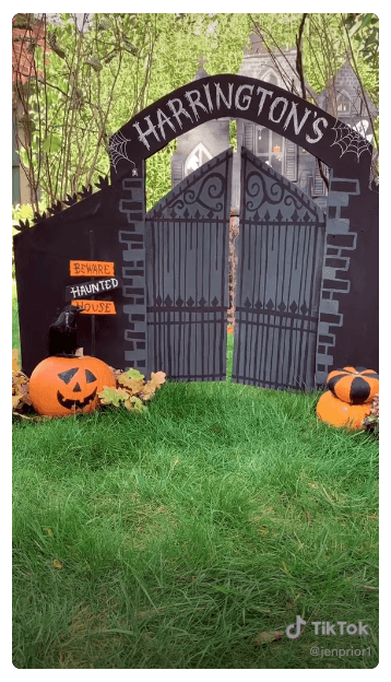 A haunted house made out of a cardboard box, surrounded by carved pumpkins