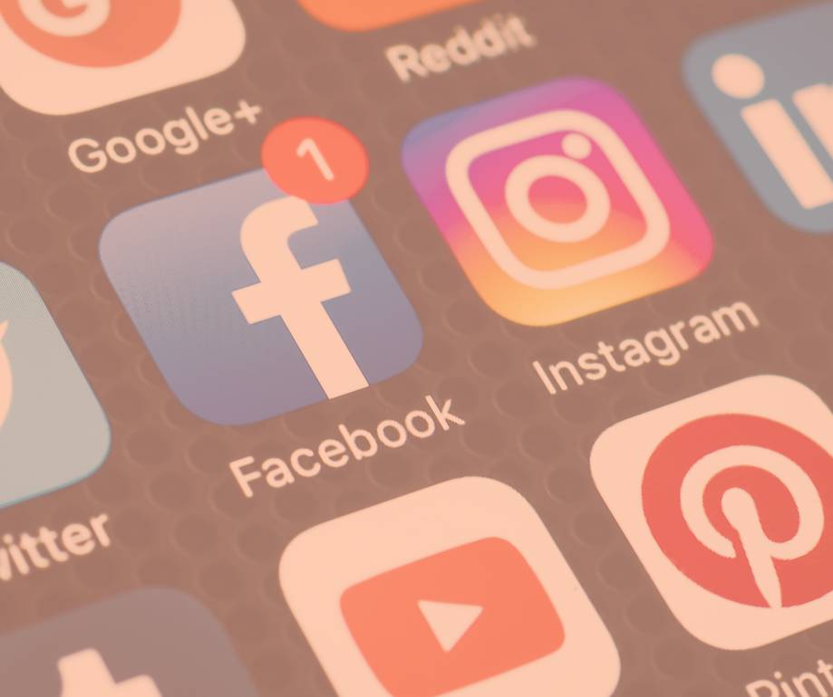Smartphone screen showing social media apps, with Facebook, Instagram, YouTube, and Pinterest icons visible; Facebook has one notification badge.