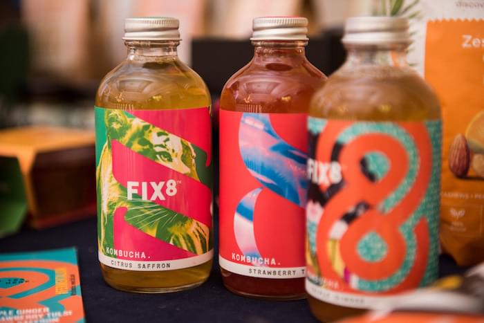 Three bottles of Fix 8 Kombucha in different flavours with colourful, modern graphics on the labels.
