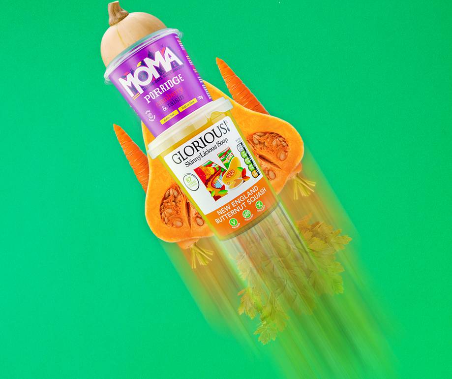 A digitally manipulated image featuring a bottle of soup with vegetables, a can of porridge on top, and carrots and pumpkin slices on a bright green background.