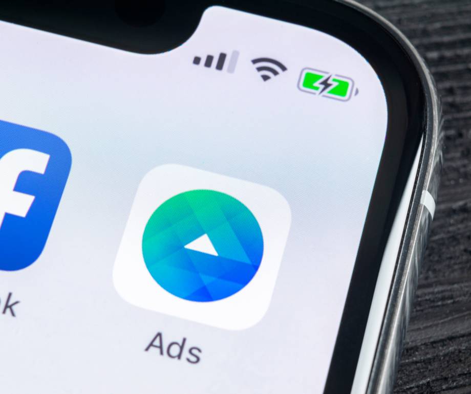 Close-up of a smartphone screen displaying Facebook and Ads app icons with signal, Wi-Fi, and battery icons at the top.