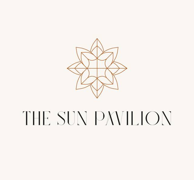 A minimalistic logo with a symmetrical geometric sun or flower design in brown, above the text 'The Sun Pavilion' in black on a light beige background.