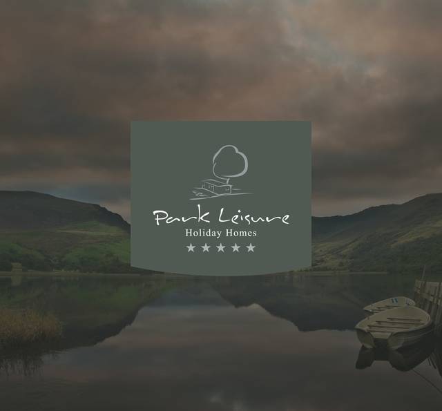 Scenic lake with boat and hills, cloudy sky, and a central overlay featuring 'Park Leisure Holiday Homes' logo with stars.