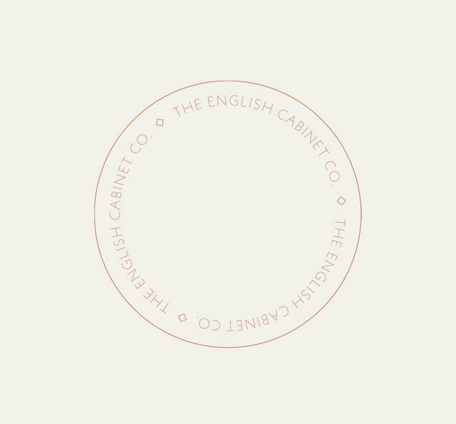 A circular logo with thin red text on a light background reading "The English Cabinet Co." arranged around the circle.