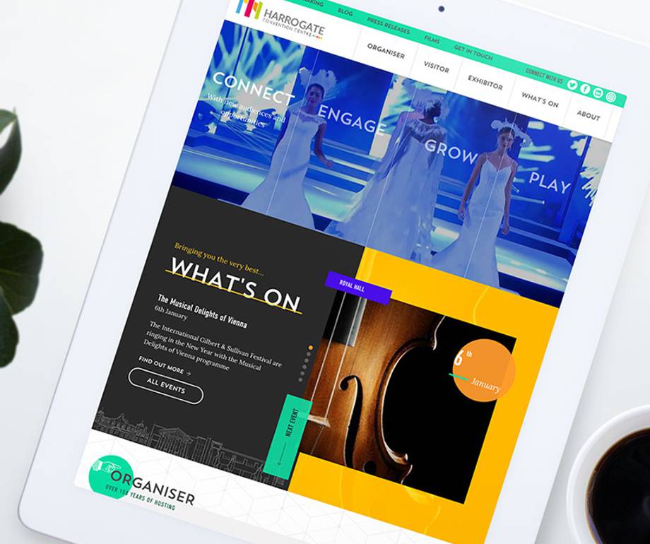 A tablet displaying a colourful website for Harrogate Convention Centre with images of performers, event details, and a navigation menu.