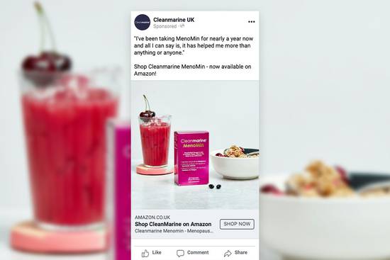 A glass of cherry smoothie with cherries on top, a box of Cleanmarine Menomin supplements, and a bowl of cereal on a white surface.