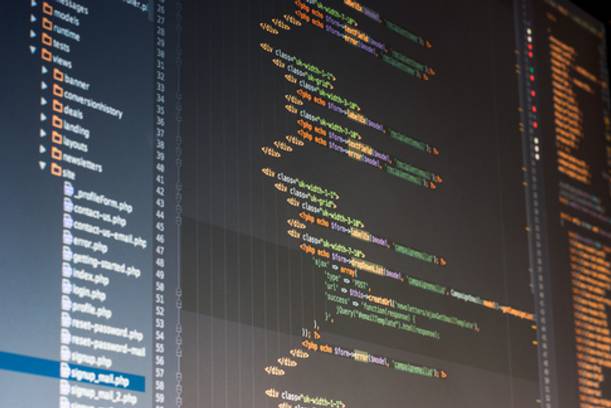 Close-up of a computer screen displaying colourful lines of programming code arranged vertically.