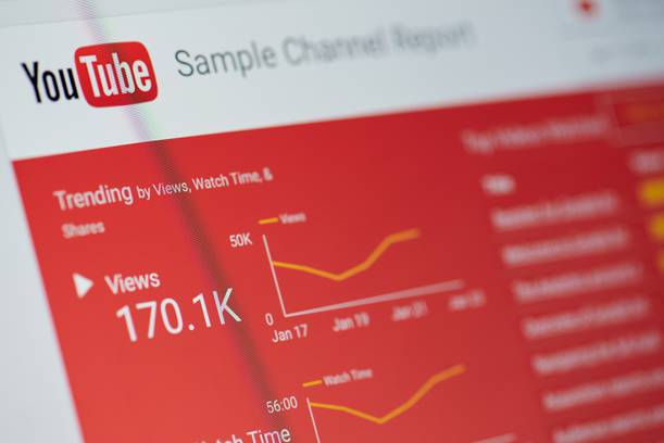 YouTube analytics dashboard with views count (170.1K), trending graph, and sample chart report on a blurred background.