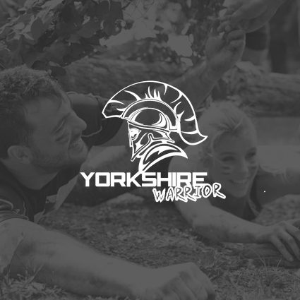 Two children in a muddy outdoor setting with a "Yorkshire Warrior" logo overlay, smiling and engaging in playful activity.